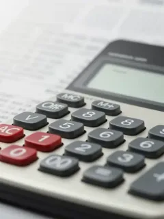Calculator displaying higher interest rates on student loan documents, symbolizing the financial burden of rising rates by 2026.